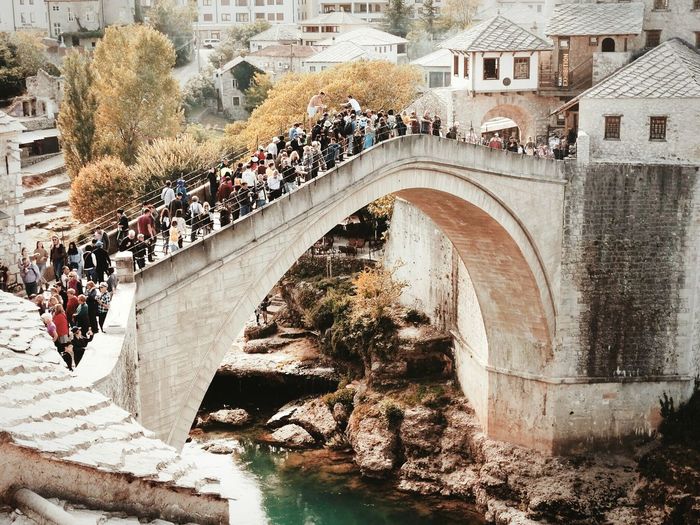 People on bridge over river