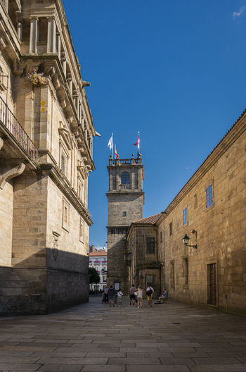 People in front of historic building against sky