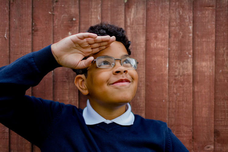 Portrait of young man standing against wall
