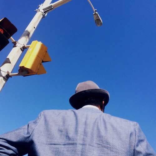 Low angle view of man against blue sky