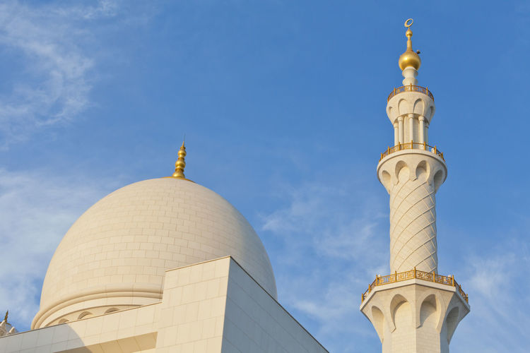 Minaret and the dome of the mosque against blue skies in abu dhabi, uae
