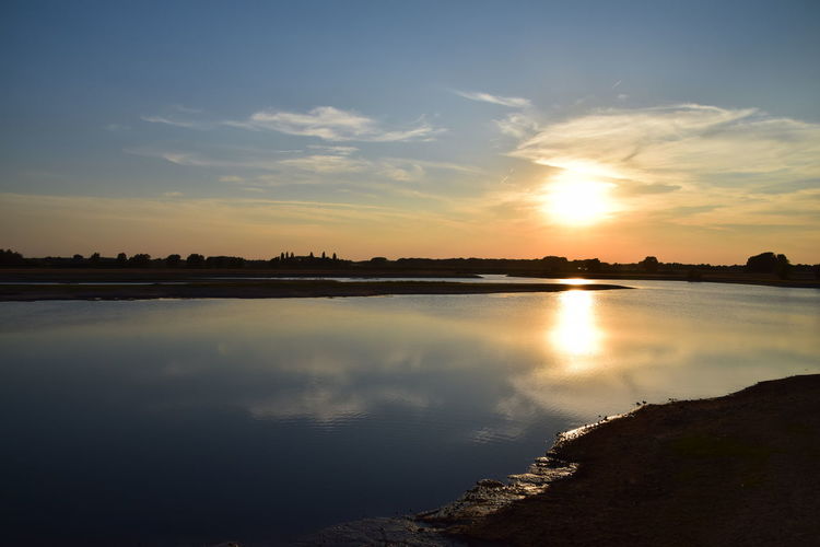 Scenic view of lake against sky during sunset