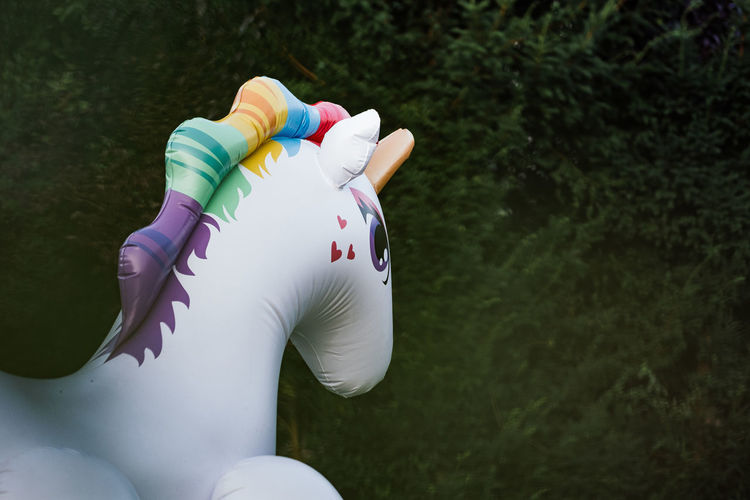 Rear view of inflatable unicorn head in front of trees
