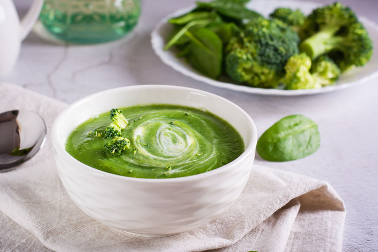 Fresh broccoli puree soup in a bowl on the table. vegetarian food.