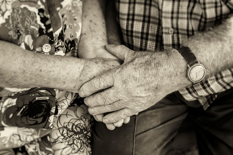Midsection of senior couple holding hands