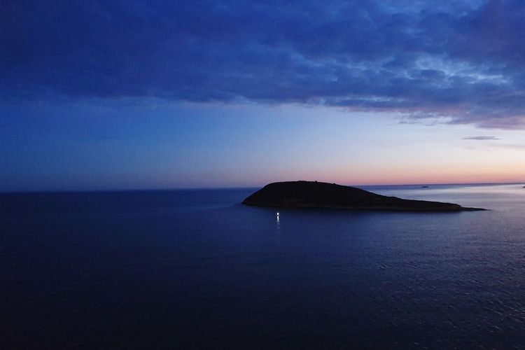 Scenic view of sea against sky at sunset