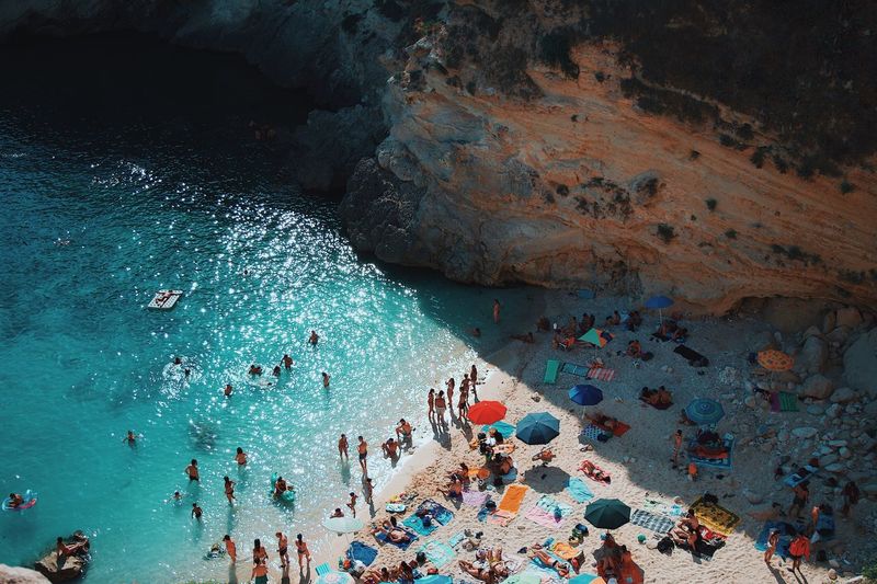 High angle view of people at beach by mountain