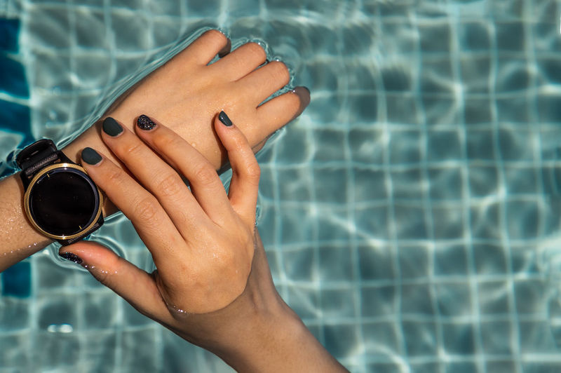 Close-up of woman hand in swimming pool