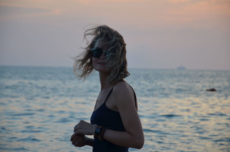 Full length of woman on beach against sky during sunset