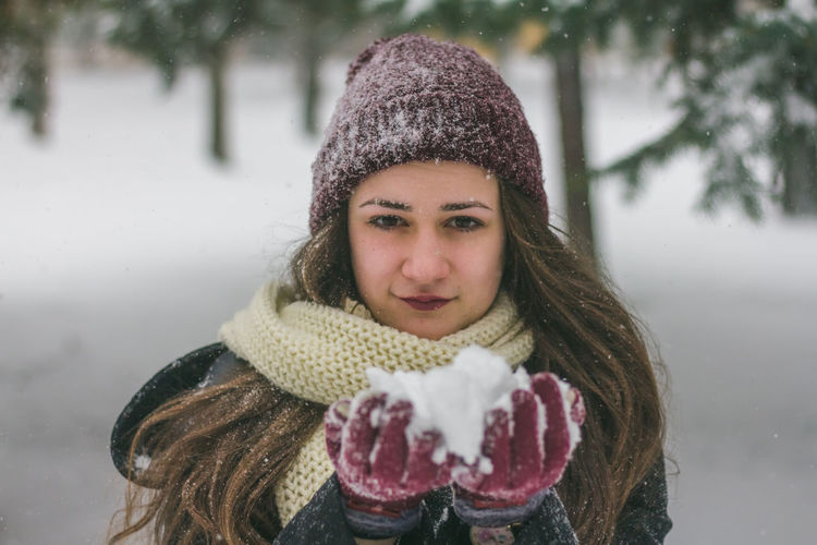 Close-up portrait of woman holding snow