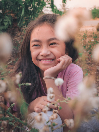 Smiling girl looking away by plants