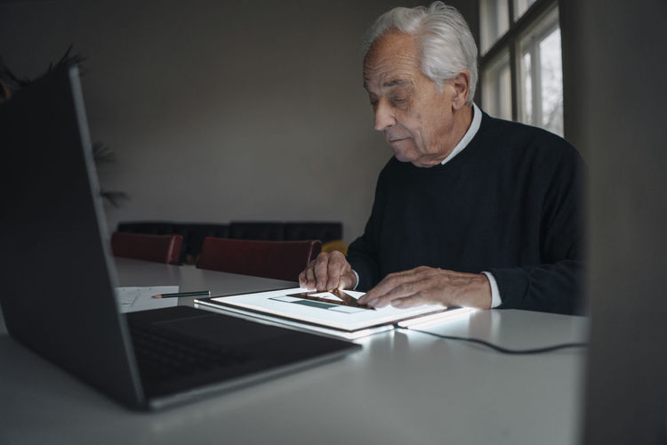Senior man using tablet with architectural plan