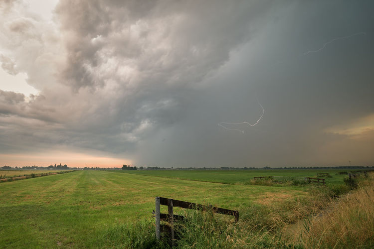 Strong thunderstorm over the dutch polder landscape with lightning flash in the clouds