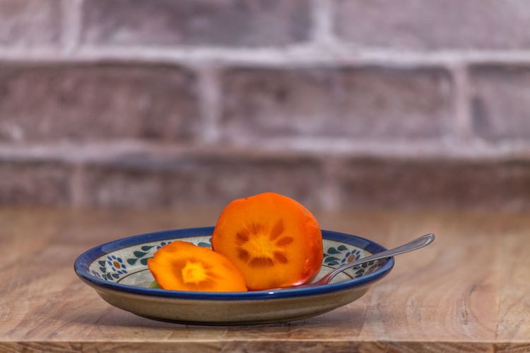 Close-up of orange fruits in bowl on table