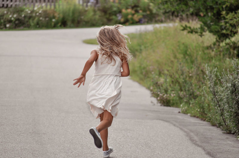 Rear view of woman walking on road