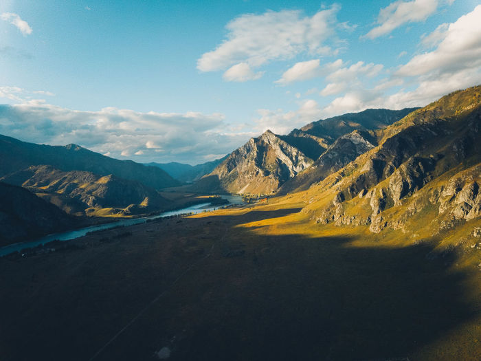 Bright yellow textured mountains against a blue sky, aerial view. sunset. drone shot