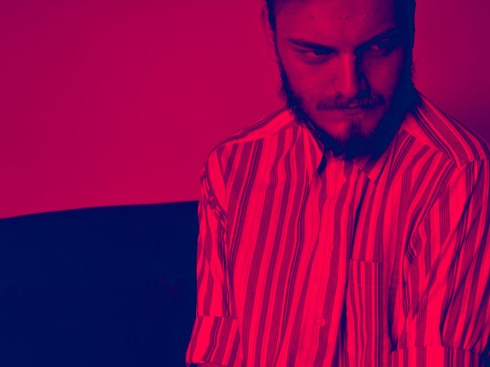 Portrait of young man against red background