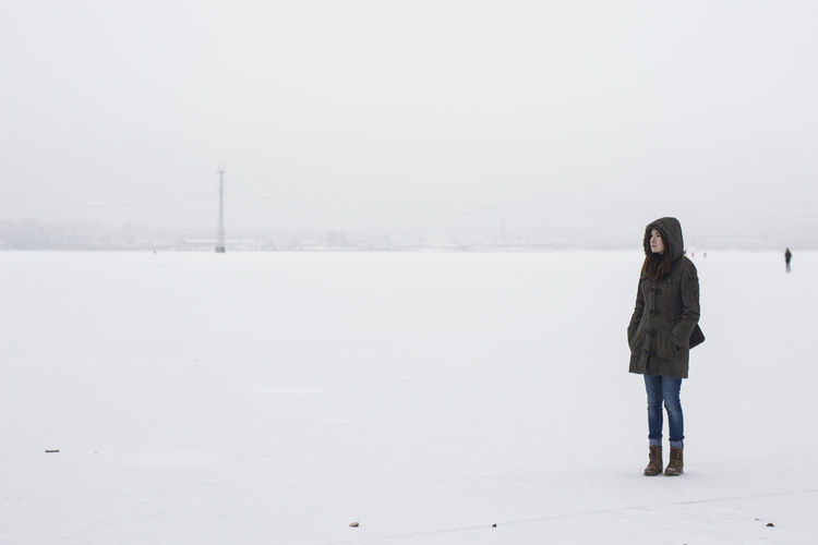 Full length of woman standing on snow against clear sky