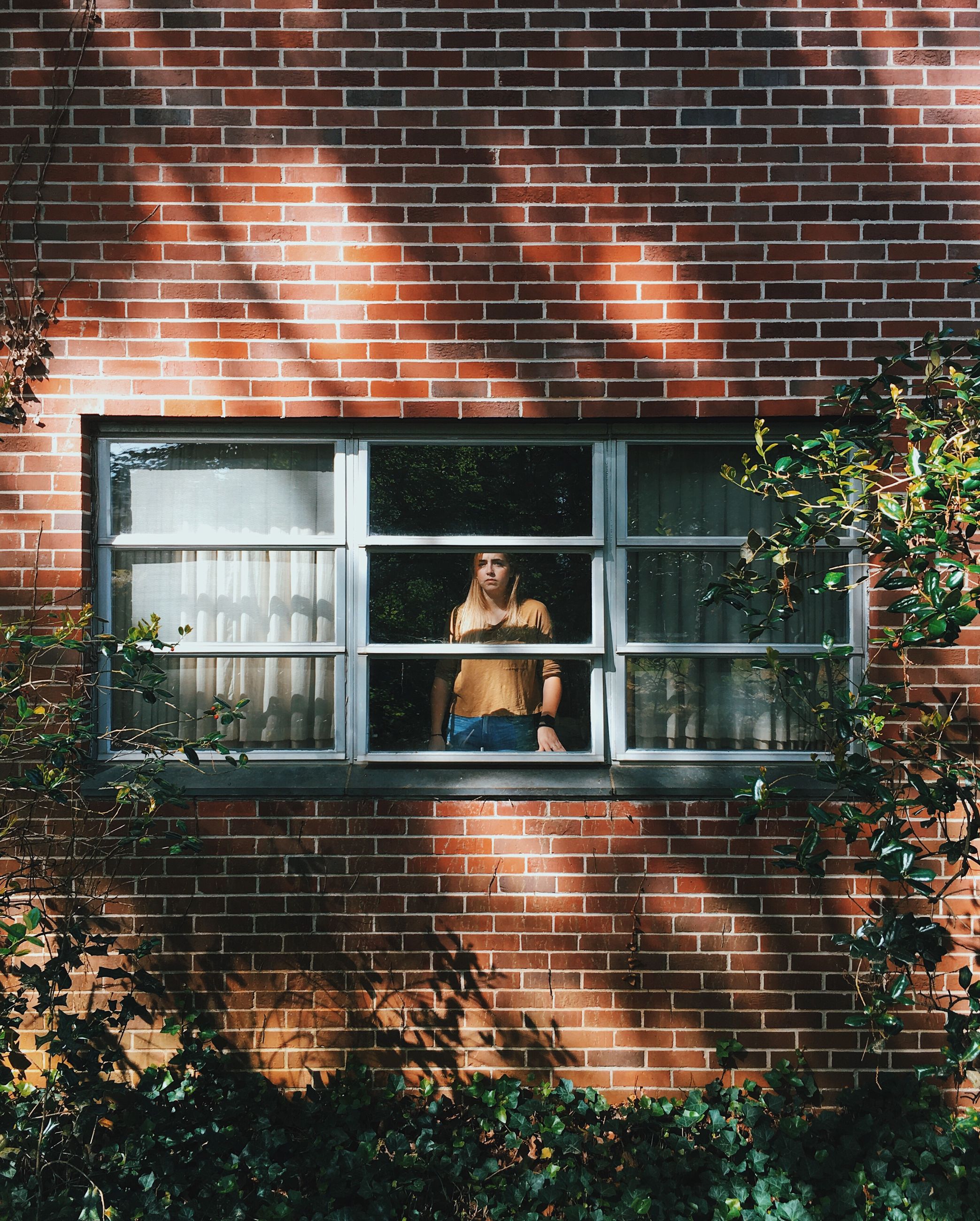 brick wall, window, building exterior, young adult, real people, one person, young women, architecture, full length, lifestyles, built structure, day, outdoors, leisure activity, standing, women, tree, people
