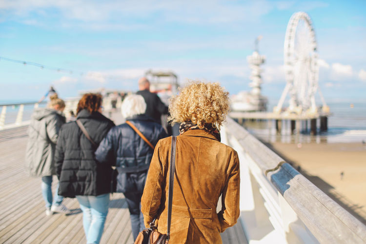 Rear view of tourists on pier