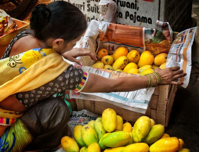 High angle view of vendor with mangos in market
