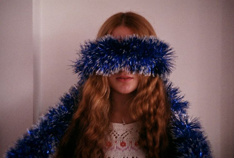 Close-up of young woman with blue tinsel