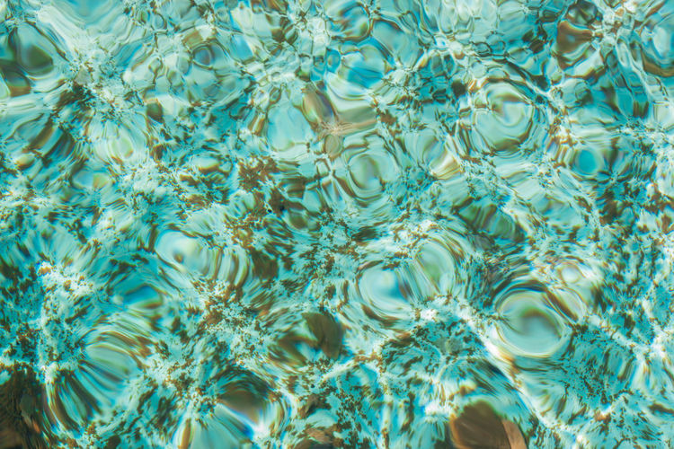 Blue swimming pool water surface texture background.
