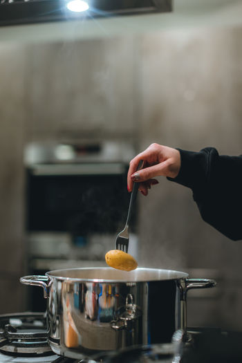 Cropped hand of man preparing food in kitchen