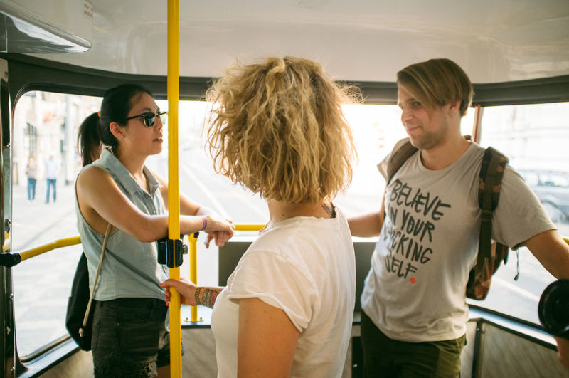 Friends talking while standing in bus
