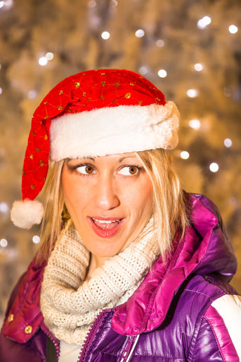 Close-up of smiling mature woman wearing santa hat during christmas