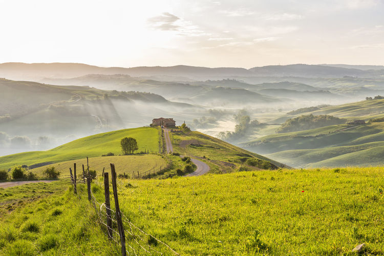 Rolling rural italian landscape view with morning mists in the valley