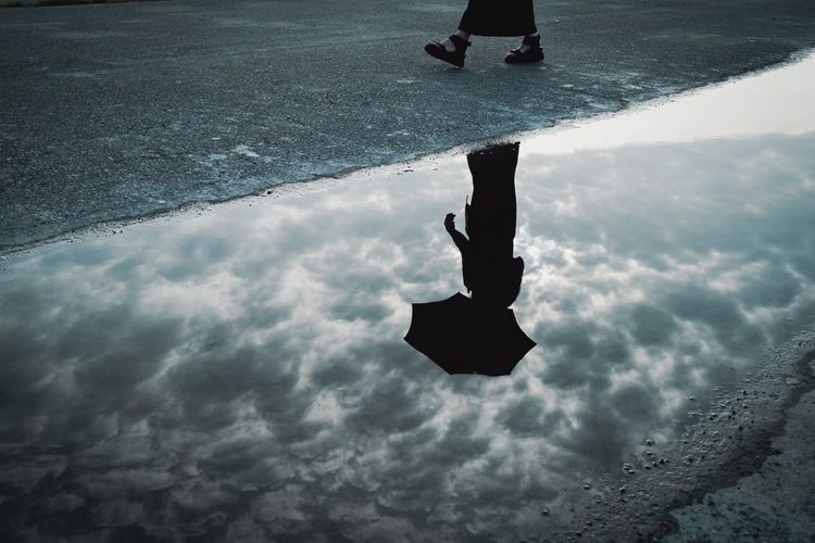 Low section of man walking on puddle