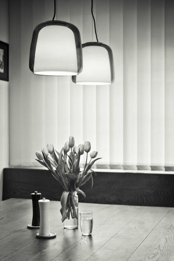 Flower vase on table against wall at home
