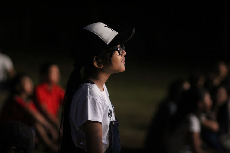 Side view of girl looking away on land at night