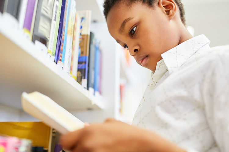 Boy reading book in library