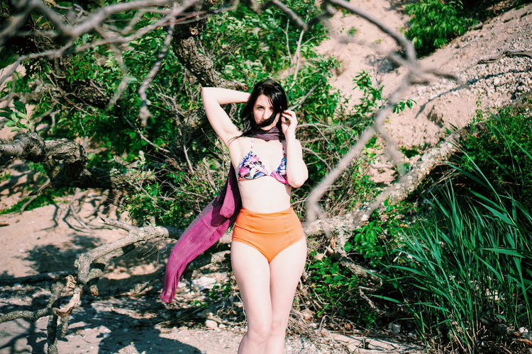 Portrait of woman standing by plants