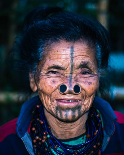 Apatani tribal women facial expression with her traditional nose lobes and blurred background