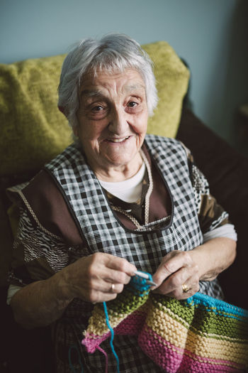 Portrait of smiling senior woman with knitting
