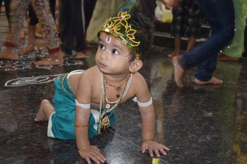 Baby boy in krishna costume while crawling on floor