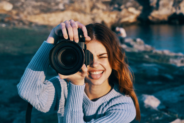 Portrait of smiling woman holding camera
