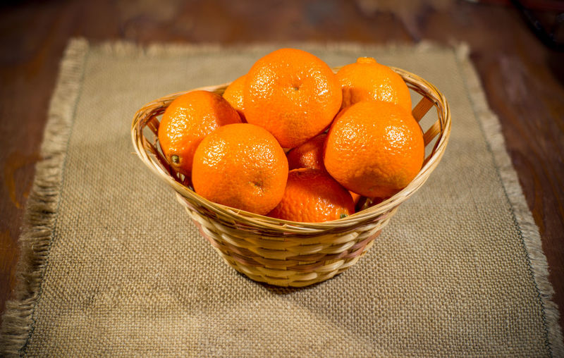 High angle view of orange fruits in basket on table