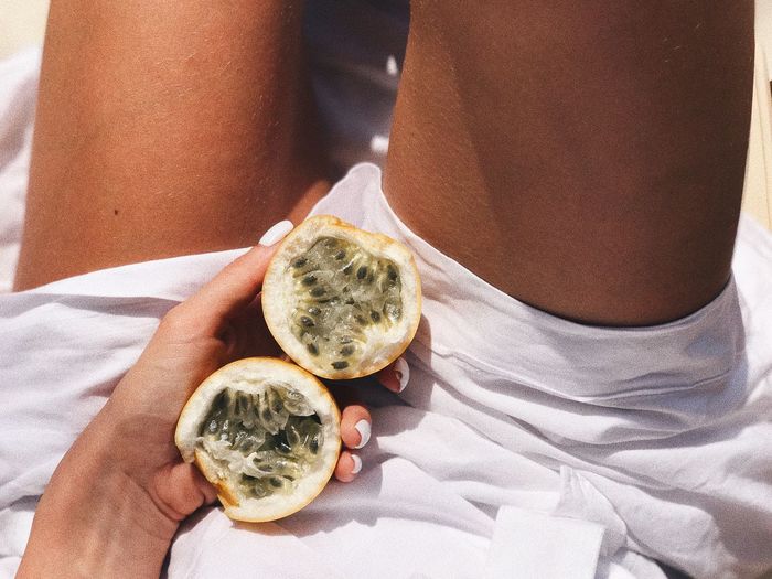 High angle view of woman holding passion fruit