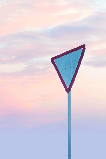Low angle view of sign against sky during sunset