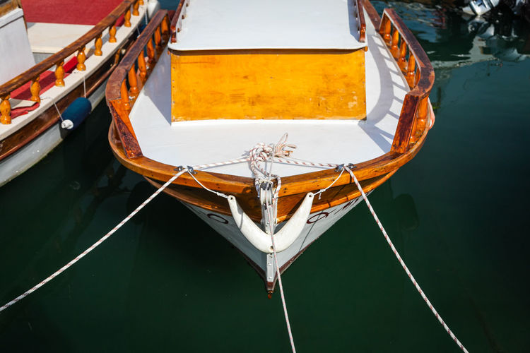 Wooden side of the boat, painted white and brown, with a beautiful wooden fence 