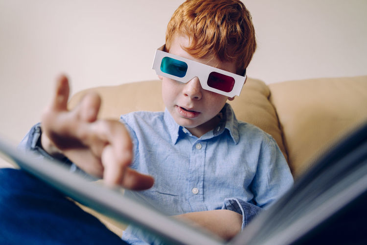 Boy gesturing while wearing 3-d glasses