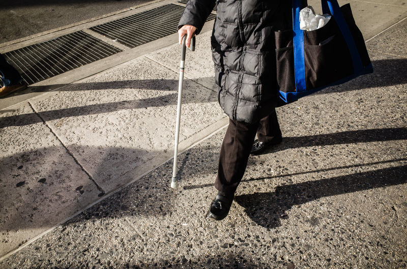 Low section of man walking on street