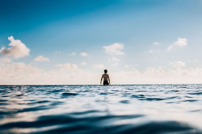MAN SURFING ON SEA AGAINST SKY