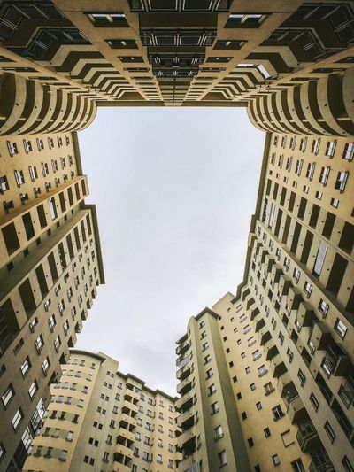 Directly below shot of buildings against sky