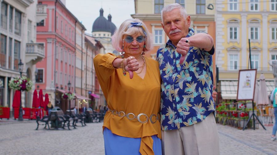Portrait of senior couple gesturing against building