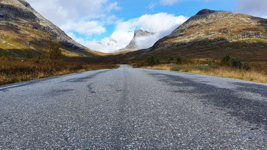 Road amidst snowcapped mountains against sky